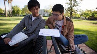 two students studying math together outside